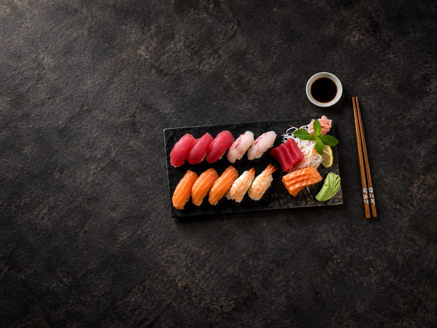 Tobiko sushi and sashimi platter with soy sauce and chopsticks